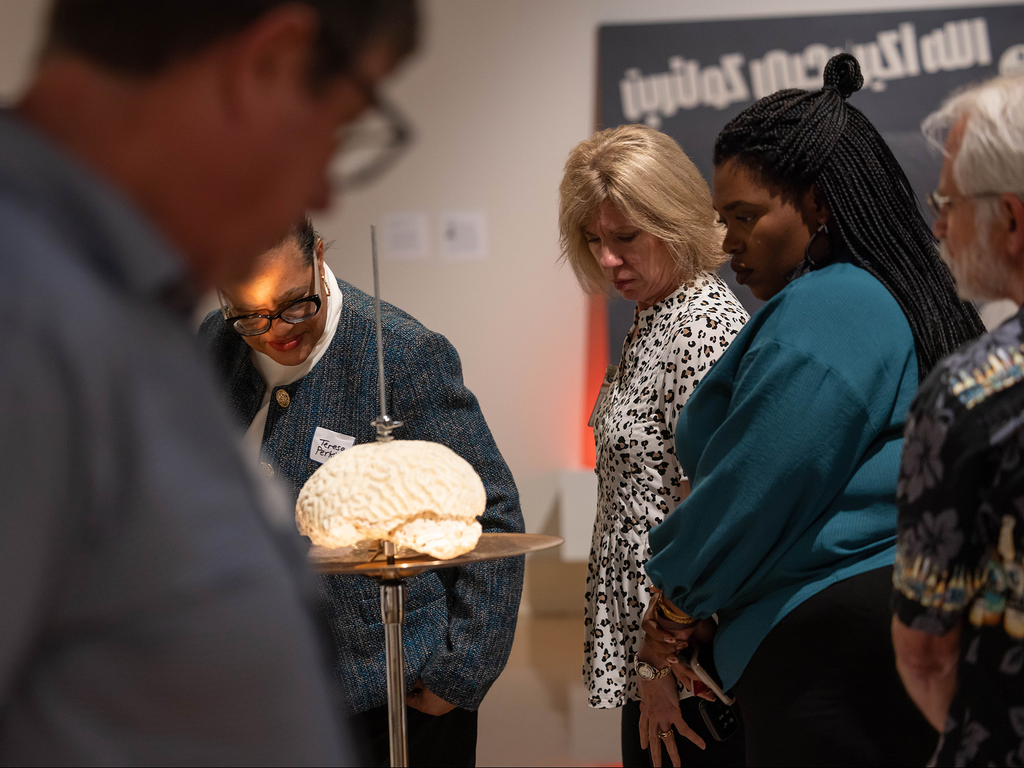 Dr. Teresa Perkins, professor in the School of Dentistry, from left, Dr. Robyn MacSorley, director of the School of Nursing, Deidra Morgan, assistant professor in the School of Nursing and Dr. David Brown, cell and molecular biology professor, take a closer look at a Jamal Cyrus mixed media piece during the UMMC Academy for Excellence in Education's event at the museum.